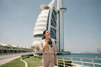 Touriste photographiant la facade emblématique du Burj Al Arab depuis le pont d'accès à Dubaï
